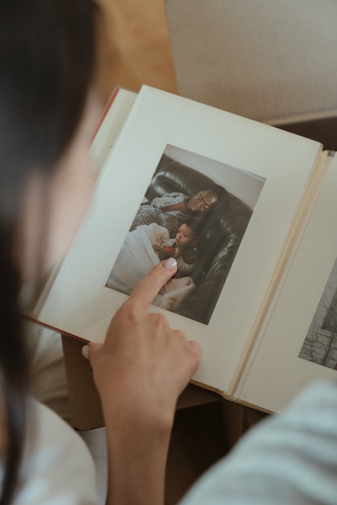 A person reminiscing through a family photo album, highlighting precious moments.