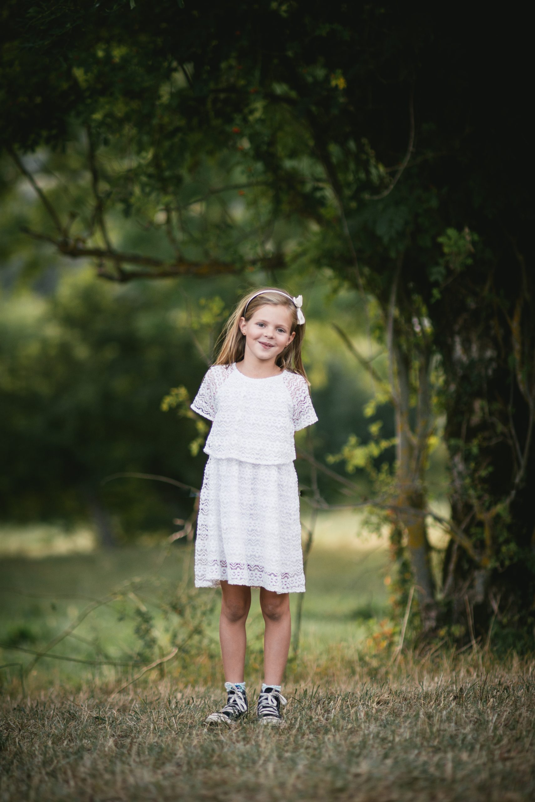 Fille en robe blanche dans un décor naturel à l'heure dorée