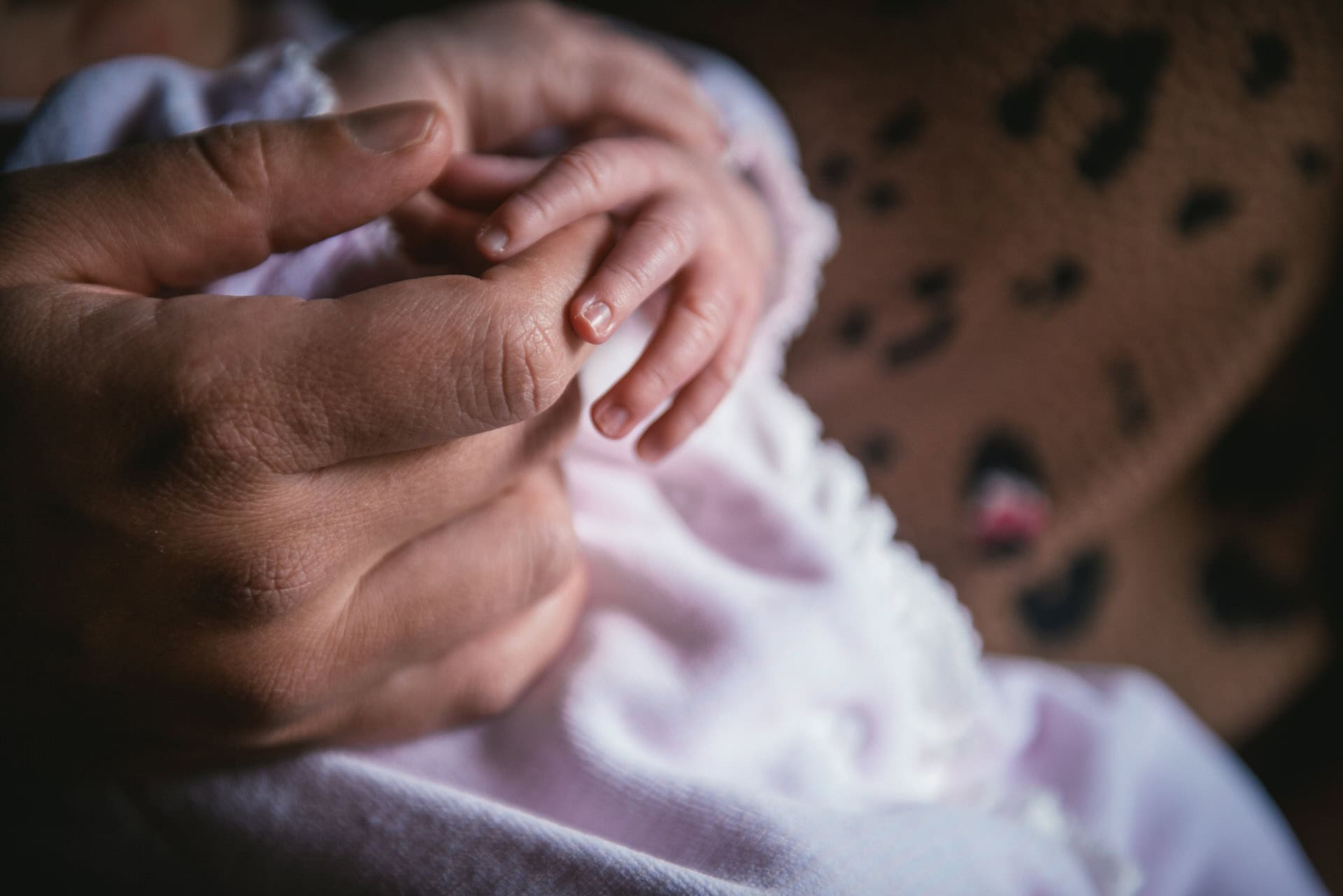 Nouveau-né endormi dans les bras de sa mère, séance naissance à Aix